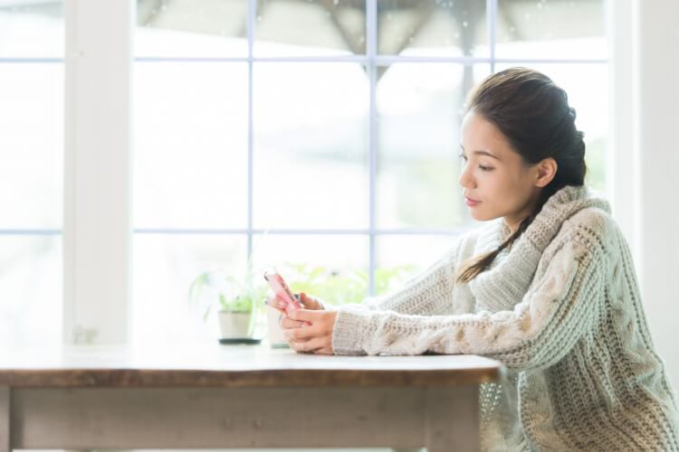 スマホで整骨院を検索する女性