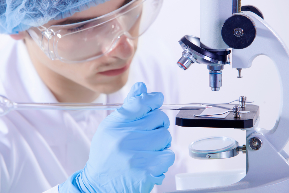 Image of man scientist working in laboratory with microscope